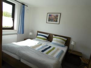 a bedroom with a bed with two pillows and a window at Ferienwohnung Schäfer in Waldbreitbach