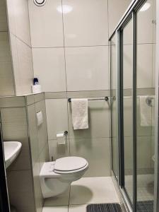 ein Bad mit einem WC und einer Glasdusche in der Unterkunft Cozy Escape in Windhoek