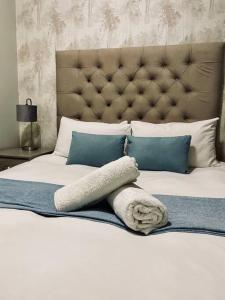 ein weißes Bett mit einem großen Kopfteil und Kissen in der Unterkunft Cozy Escape in Windhoek