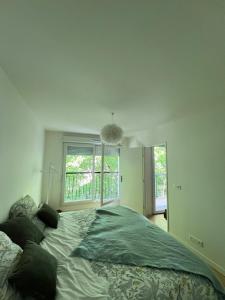 une chambre avec un grand lit devant une fenêtre dans l'établissement 2 pièces standing entre Disneyland et Paris, à Neuilly-Plaisance