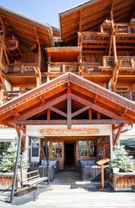 a large wooden building with a large roof at Hôtel Au Chamois d'Or by Les Etincelles in L'Alpe-d'Huez