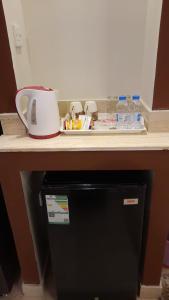 a counter top with a coffee pot and water bottles at دار السلام للشقق المخدومة الجوف دومة الجندل in Dawmat al Jandal