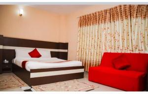 a bedroom with a bed and a red chair at Doleshwor Village Resort and Farm House Pvt Ltd in Bhaktapur