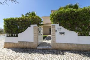 a house with white walls and trees at Villa Tulipa in Albufeira