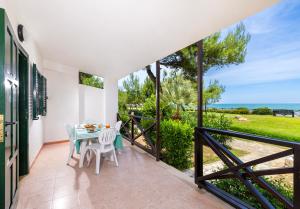 balcón con mesa, sillas y vistas al océano en Crovatico Club Vacanze en Vieste
