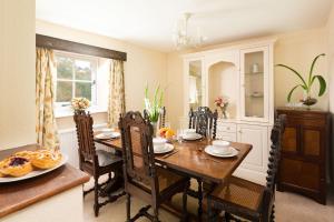a dining room with a wooden table and chairs at Upper Instow Beach Cottage in Instow
