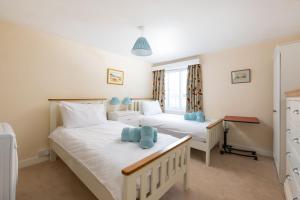 a bedroom with two beds and a desk at Upper Instow Beach Cottage in Instow