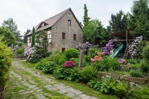 Ferienhaus zum Rundling في بيرنا: حديقة امام بيت حجري به ورد