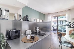 een keuken met een aanrecht met een magnetron en een tafel bij Design suite con terrazza in via Masera 6 in Milaan