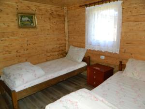 a room with two beds in a log cabin at Prenoćište Stupovi in Novi Pazar