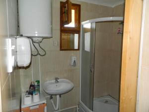 a small bathroom with a sink and a shower at Prenoćište Stupovi in Novi Pazar