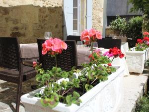 a table with flowers in a planter on a patio at Hôtel de France et de Russie in Thiviers