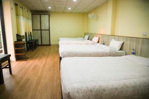 a hotel room with three beds and a desk at Doleshwor Village Resort and Farm House Pvt Ltd in Bhaktapur