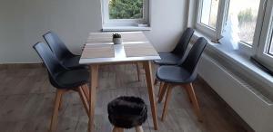 uma mesa com quatro cadeiras sentadas ao lado de uma janela em Chalet Maria HOT TUBE SAUNA em Loucná pod Klínovcem