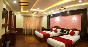 a hotel room with two beds and a television at Samsara Boutique Hotel in Kathmandu