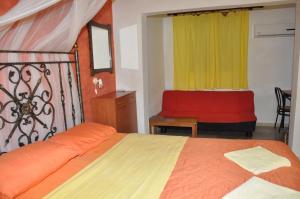 - une chambre avec un lit et un canapé rouge dans l'établissement Kahlua, à Liapades