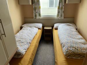 Postel nebo postele na pokoji v ubytování Spacious & welcoming 6th Berth Caravan California Cliffs Holiday Park, Norfolk Coast