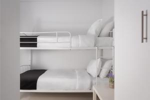 1 dormitorio con litera y almohadas blancas en Varkiza Seaside Apartment, en Vari