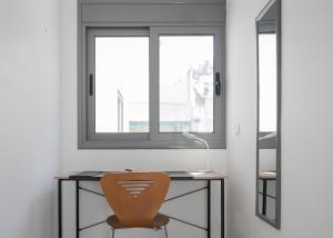 a desk with a chair next to a window at Varkiza Seaside Apartment in Vari +17 photos