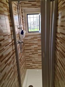 a small bathroom with a shower with a window at Casa MiDa, vista panoramica sulla Maiella in Castelfrentano