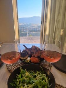 una mesa con dos copas de vino y un plato de comida en Casa MiDa, vista panoramica sulla Maiella en Castelfrentano