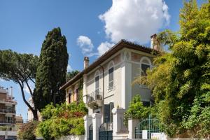 a white house with a balcony and trees at Cardilli Trastevere in Rome