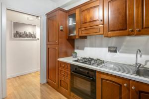 a kitchen with wooden cabinets and a stove top oven at Cardilli Trastevere in Rome