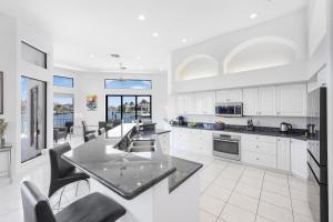 a kitchen with white cabinets and a black counter top at 951 Ruby Court in Marco Island