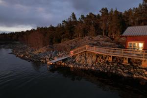 a building with a dock next to a river at Kustvy - En Destination intill Havet in Skärplinge +66 photos