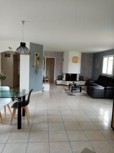 ein Wohnzimmer mit einem Sofa und einem Tisch in der Unterkunft Le chêne blanc in La Genétouze
