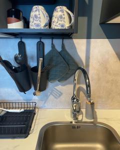 a kitchen counter with a sink and a shelf with dishes at Nordkust - Unikt boende med havsutsikt in Skärplinge