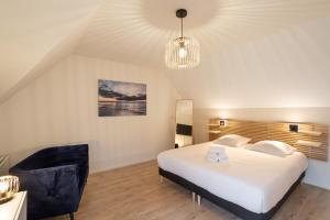 - une chambre avec un grand lit blanc et un lustre dans l'établissement La Petite Maison Dans la Prairie - Havre de paix, à Rennes
