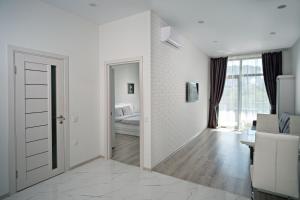 Апартаменты в Аркадии - Arcadia Sky Apartments في أوديسا: غرفة بيضاء مع باب يؤدي إلى غرفة النوم