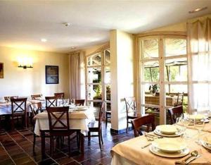 Casa Rural Marialba في Monte la Reina: غرفة طعام مع طاولات وكراسي ونوافذ
