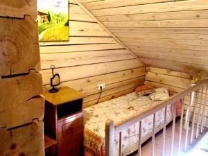 Habitación pequeña con cama en una pared de madera. en Villa Romturas, en Aukštadvaris