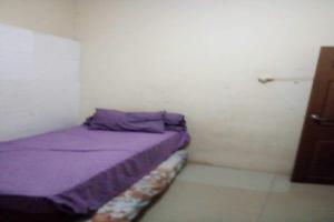 a small room with a purple bed in it at OYO 93863 Dv Homestay Syariah Genteng in Surabaya