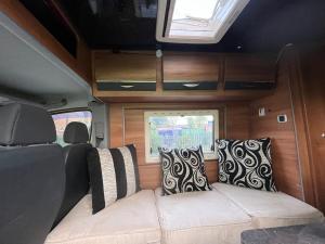 a couch in the back of a van with pillows at Waterside campervan in Manchester