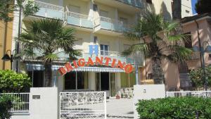 a sign in front of a building with palm trees at Hotel Brigantino in Milano Marittima +3 photos