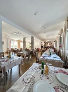 una sala da pranzo con tavoli e sedie con tovaglie bianche di Hotel Brigantino a Milano Marittima