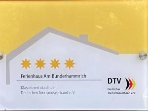 un panneau indiquant un bâtiment avec des étoiles sur celui-ci dans l'établissement Ferienhaus am Bunderhammrich 25184, à Bunde