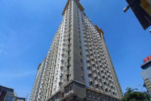 een hoog wit gebouw met een kruis erop bij Capital O 93845 Apartemen Gateway Cicadas By M2 Property in Bandung