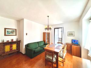 sala de estar con sofá verde y mesa en Appartamento Molina, en Molina di Ledro