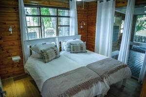 Bonnievale的住宿－Olifantskrans River Cabins，一间设有床铺的卧室,位于带窗户的房间内