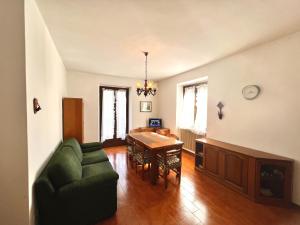 sala de estar con sofá verde y mesa en Appartamento Molina, en Molina di Ledro
