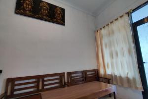 Cette chambre dispose d'une table en bois et d'une fenêtre. dans l'établissement OYO 93867 Minso Inn Sepanjang, à Yogyakarta