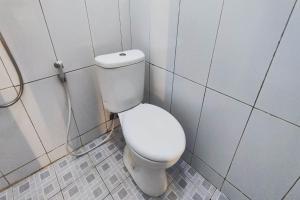 a bathroom with a white toilet in a stall at OYO 93867 Minso Inn Sepanjang in Yogyakarta