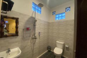 a bathroom with a toilet and a sink at Capital O 93844 Arta Adi Homestay in Bangli