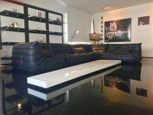 a living room with a black leather couch and a table at Modern Apartment near the Center by Platform 357 in Strovolos