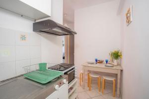 a kitchen with a stove and a table with stools at A4 - Rosemary Apartment in Nydri +29 photos