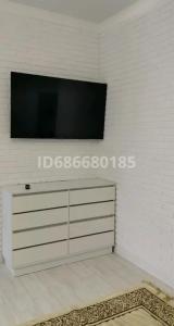 - un salon avec une télévision sur un mur blanc dans l'établissement Сдам в аренду квартиру, à Taldykolʼ